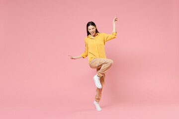 Fototapeta na wymiar Full length of young brunette excited overjoyed attractive latin woman 20s in yellow casual shirt do winner gesture outstretched hands celebrating isolated on pastel pink background studio portrait.