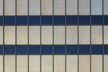 Parallel lines intersect perpendicularly and divide the windows of a modern building. Rectangular panels.