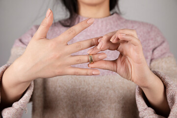 sad woman holding wedding ring