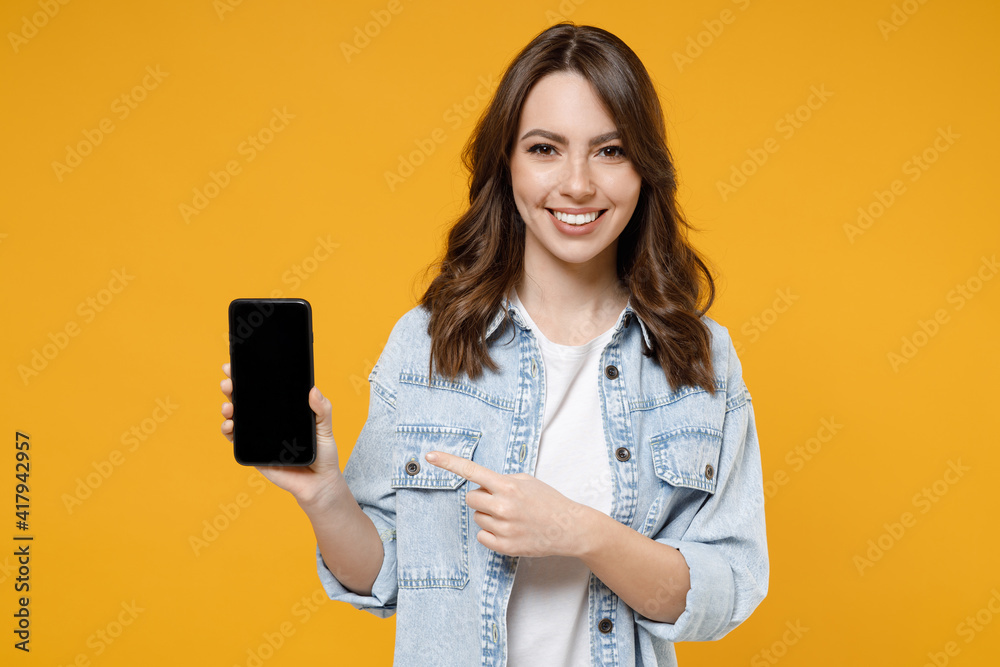 Wall mural young smiling happy fun woman 20s wear stylish casual denim shirt white t-shirt point index finger o