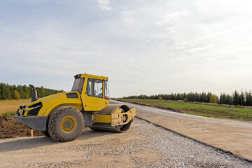 Fototapeta na wymiar Road Roller on the construction of a new road. Construction machinery. Dedicated Construction machinery for handling bulk materials