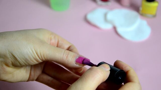 Close up of woman using nail buffer when doing manicure, polishing nails at home. Smiling lady testing new beauty products and modern cosmetics, doing morning makeup or daily nail care routine