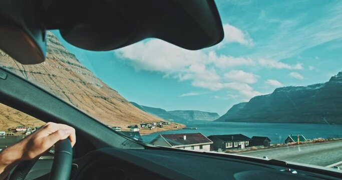Views of a small seaside village from a car in motion. 