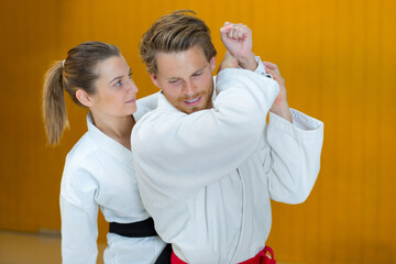 man and woman fighting at aikido training