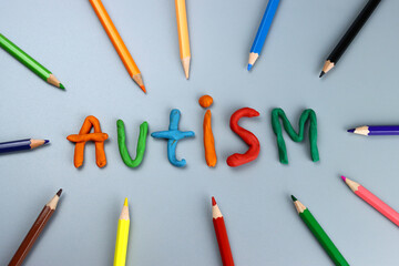 autism word from made of colored modeling clay or plasticine on a gray background