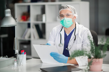 Before starting the appointment, the doctor examines the patient's medical history, which was brought by the clinic administrator.