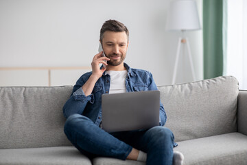 Positive middle-aged man with laptop talking on smartphone - Powered by Adobe