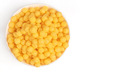 Corn balls for breakfast. White plate on a white plate with bran flakes, dry breakfast.

