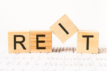 Word reit. Wooden small cubes with letters isolated on white background with copy space available.Business Concept image.