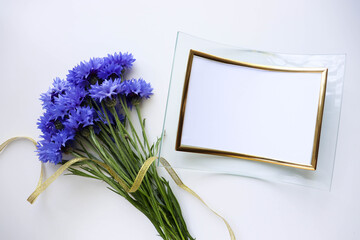postcard layout. small bouquet of blue cornflowers on a white background and space for text