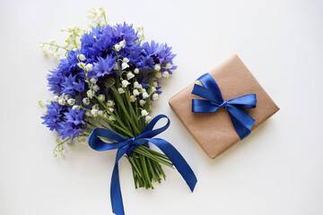 postcard layout. small bouquet of blue cornflowers on a white background and space for text