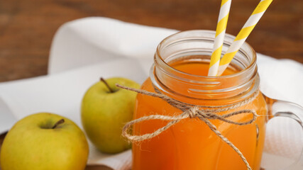 Apple and carrot juice in glass, fresh vegetables and fruits on wooden background. Rustic style. Homemade drink with vitamins
