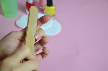Close up image of woman using nail buffer when doing manicure, polishing nails at home. Smiling...
