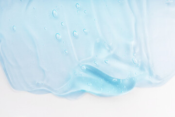Clear skincare product smudge closeup. Cream gel blue transparent cosmetic sample with bubbles isolated on white background. Face serum texture. Hand sanitizer, hygiene liquid gel