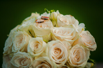 Wedding gold rings on a bouquet with white roses