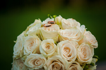 Wedding gold rings on a bouquet with white roses