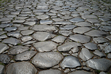Historic Roman stone paved road detail in Rome city centre, Italy
