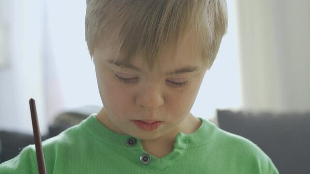 Close-up of Boy with Down Syndrome drawing at home