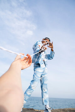 Men pulling while setting free from rope against sky