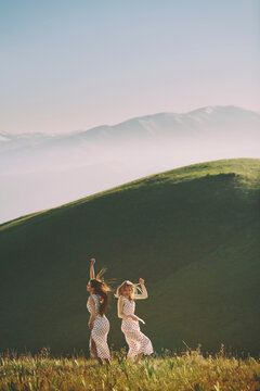 Lesbian couple dancing against mountain