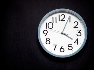 white round analog clock on black background