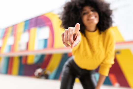 Woman pointing finger while standing outdoors