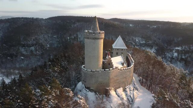Aerial view of medieval castle Kokorin nearby Prague in Czechia Central Europe. Medieval gothic castle Kokorin, Kokorinsko area in Czech Republic. Footage inn winter covered by snow at sunrise.
