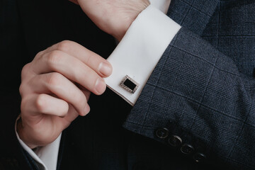 Close up of businessman wearing cufflinks. Elegant young fashion business man wearing suit.