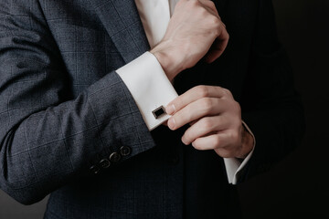 Close up of businessman wearing cufflinks. Elegant young fashion business man wearing suit.