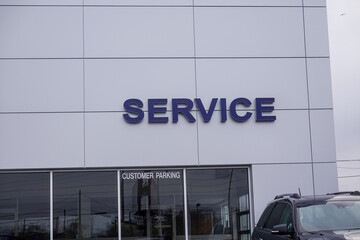 Modern building with a large glass window. The word service in blue letters is on the facade