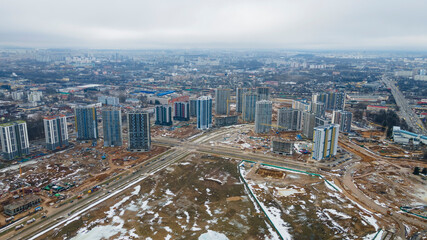 Construction of high-rise resedential buildings. The construction industry with working equipment. View from above. Eye bird view of new resedential district.