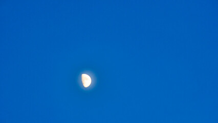Crescent in the blue evening cloudless sky. Moon in the sky. Design concept. Space for text.