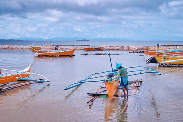 Tropical fishing boats harbour at rainy day. Siargao, Philippines.