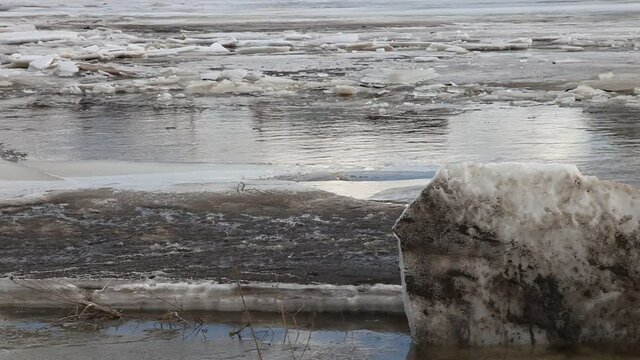 Seasonal spring ice drift in Russia, a view from the shore with ice floes of the floating ice on the river water