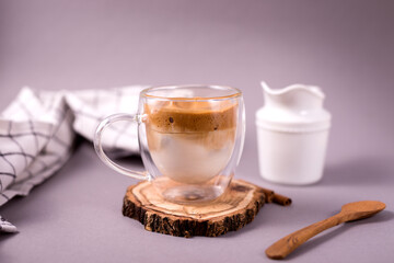Dalgona Coffee. Whipped icing drink with instant coffee popular in Korea Creamy cocktailin a transparent double wall glass mug.