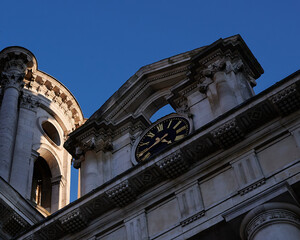 Looking up at old building and its clock face with winter sun shine and shadows © London Time