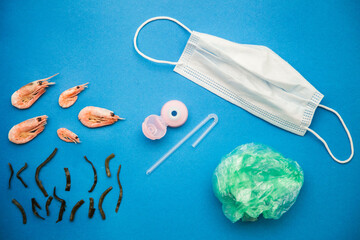 Children's applique on the theme of an ecological disaster after the consequences of the coronavirus covid 19. On a blue background, the ocean, in which real shrimps and algae swim. 