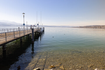 Obraz premium empty pier without ships on the lake in bright sunshine, at this landing pier people can take a boat tour, by day