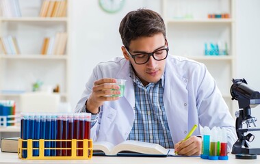 Young chemist student working in lab on chemicals