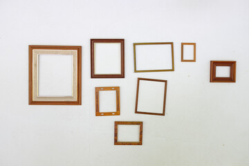 empty wooden picture frames on white wall