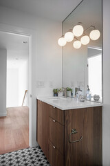 modern bathroom interior with large vanity with the lights on featuring one sink with the door open
