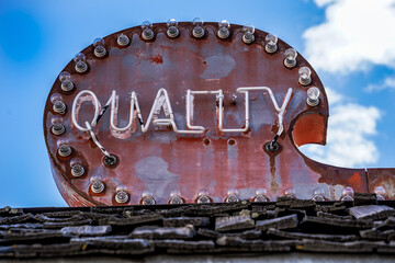 rusty old sign saying quality