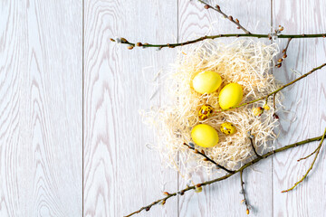 Colorful yellow chicken and quail easter eggs, nest and willow branches, spring, easter concept