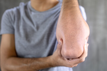 Close up of man suffering from pain in hand or elbow