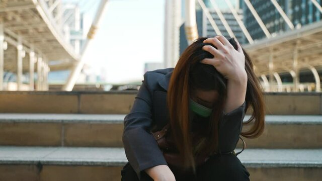 Unemployed businesswoman depressed sitting in the city. concept of company bankrupted, economic depression caused by coronavirus spreading and government lockdown