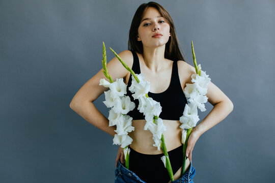Portrait of a woman with gladioli flowers in her jeans