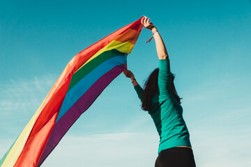 unrecognizable girl with gay pride flag