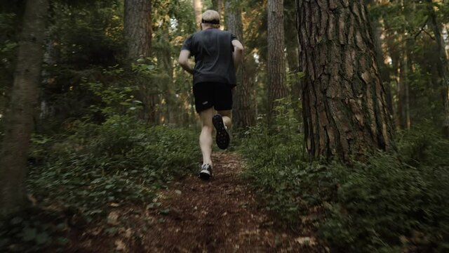 Fit Young Man Running Along A Trail In The Countryside