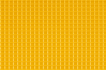 Yellow plastic checkered pattern texture. Flat lay top view.