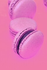Colorful pink and purple macaron cookie filled with ganache cream